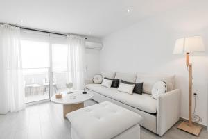 a white living room with a couch and a table at Diogenis Seaside Suite in Rethymno Town