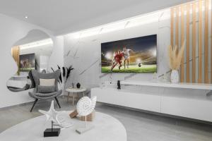 a living room with a tv on a wall at Diogenis Seaside Suite in Rethymno Town