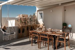 a patio with a wooden table and chairs on a balcony at Diogenis Seaside Suite in Rethymno Town