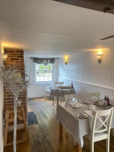 a dining room with tables and chairs and a window at Ship Stores Guest House in Clare