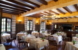 un comedor con mesas y sillas blancas en Hotel Sant Bernat en Montseny