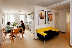 deux femmes assises à une table dans un salon dans l'établissement Gästehaus Goethe-Institut Schwäbisch Hall, à Schwäbisch Hall