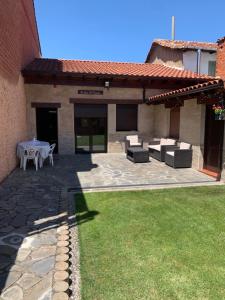 un patio con mesa y sillas y un edificio en La Casina del Cerecedo, en León