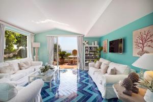 a living room with white furniture and blue walls at Villa Rita Apartments in Massa Lubrense