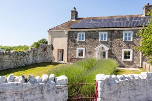an old stone house with solar panels on the roof at Hawton in Kidwelly