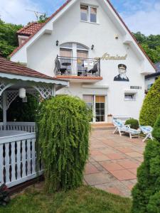 a white house with a porch and a patio at Willa Admirał in Trzęsacz +25 photos