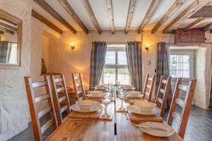 a dining room with a long wooden table and chairs at Bryntowy in Kidwelly