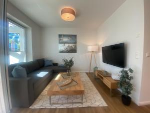 a living room with a blue couch and a tv at Hafenliebe Wiek in Wiek auf Rügen 