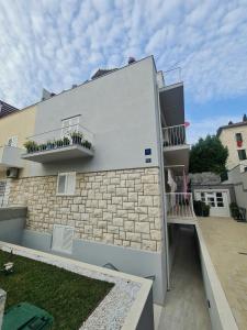 a building with two balconies on the side of it at Da Vinko Beach Apartments in Split