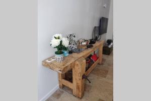 una mesa de madera con flores en una habitación en La maison de Marie, maison de ville 4 personnes, option chambre patio 2 pers supp, en Aigues-Mortes