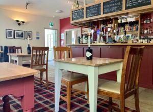 um bar com mesa e cadeiras num restaurante em The Craven Arms em Settle