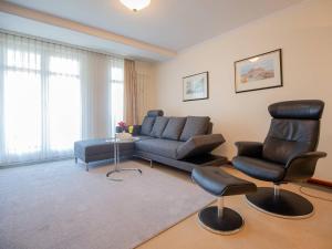 a living room with a couch and a chair at Strandvillen Binz - 1-Raum-Ferienwohnung mit Meerblick und Balkon SV-763 in Binz +1 photo