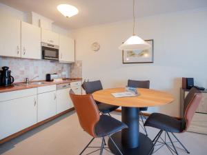 eine Küche mit einem Tisch und Stühlen im Zimmer in der Unterkunft Strandvillen Binz - 1-Raum-Ferienwohnung mit Meerblick und Balkon SV-763 in Binz