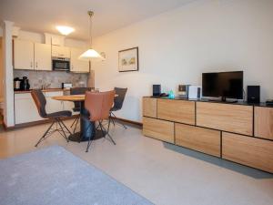 a living room with a table with a tv and a kitchen at Strandvillen Binz - 1-Raum-Ferienwohnung mit Meerblick und Balkon SV-763 in Binz