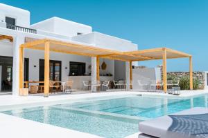a villa with a swimming pool and a house at Koukoumi Vegan Boutique Hotel in Ano Mera