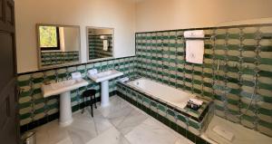 a bathroom with two sinks and a bath tub at Soho Boutique Castillo de Santa Catalina - Adults Recommended in Málaga