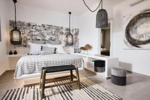 Sypialnia z łóżkiem, stołkiem i lampkami w obiekcie Terra Mare Suites w mieście Agia Irini Milos