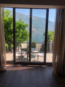 Elle offre une vue sur une terrasse avec une table et des chaises. dans l'établissement Villa Arina, à Kotor