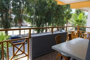 a balcony with tables and chairs and trees at Alpat Homes in Kemer