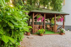 a wooden gazebo with potted plants and flowers at Vila Zahumka Free Parking in Mostar