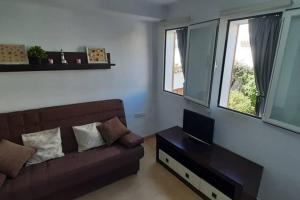 a living room with a couch and two windows at VORAMAR PORT XABIA in Jávea