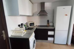 a kitchen with a white refrigerator and a microwave at VORAMAR PORT XABIA in Jávea