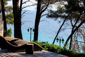 a bench sitting on a deck near the water at Nostos Hotel in Afitos