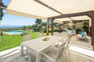 una mesa blanca y sillas en un patio con piscina en Villa Colomba by Mmega, en Lastra a Signa
