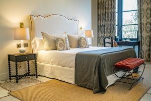 a bedroom with a bed and a table and a window at Soho Boutique Castillo de Santa Catalina - Adults Recommended in Málaga