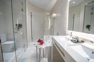 a bathroom with two sinks and a shower and a toilet at Soho Boutique Castillo de Santa Catalina - Adults Recommended in Málaga