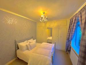 a bedroom with a bed and a chandelier and a window at Beautiful Sea View 2 Bed Home in Port Glasgow