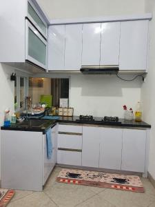 a kitchen with white cabinets and a counter top at Stay@Pitaloka in Cirebon