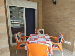 uma mesa e cadeiras com uma mesa e uma janela em Apartamento 1ª línea de playa em Oropesa del Mar