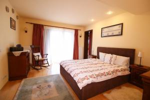 a bedroom with a bed and a desk and a window at Transylvanian Villa in Predeal +16 photos
