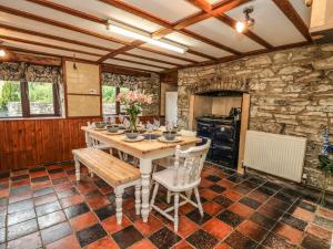 a kitchen with a table and chairs and a stone wall at Pant Y Rhedyn in Llandrindod Wells