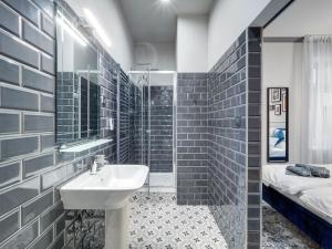 uma casa de banho com um lavatório, um chuveiro e um espelho. em A22 Boutique Suites em Budapeste