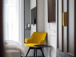 a yellow chair in a room with a mirror at A22 Boutique Suites in Budapest