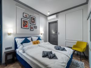 um quarto com uma cama grande e uma cadeira amarela em A22 Boutique Suites em Budapeste