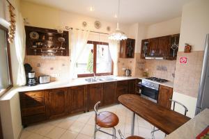 cocina con armarios de madera y mesa de madera en Transylvanian Villa, en Predeal