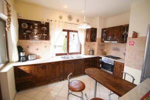 a kitchen with wooden cabinets and a wooden table at Transylvanian Villa in Predeal