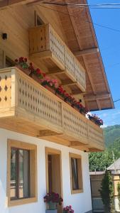 un balcón en el lateral de una casa con flores en Anahouse en Vişeu de Sus