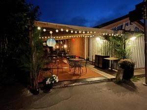 a patio with a table and chairs and lights at Mini Villa Stockholm Älvsjö S61 in Stockholm
