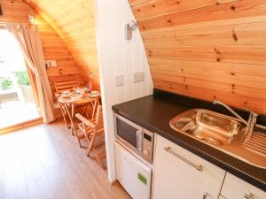 a kitchen with a sink and a table in a room at Lovesome Pod in Northallerton