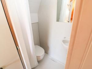 a white bathroom with a toilet and a urinal at Lovesome Pod in Northallerton