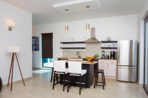 a kitchen with a table and chairs and a refrigerator at Bella Luna Beach Condo #227473 in West End