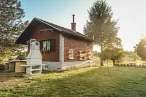 una pequeña casa de ladrillo con una gran ventana en Ruralna kuća za odmor LOVRAK en Budrovac