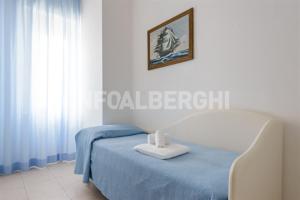 1 dormitorio con 1 cama y una foto en la pared en Hotel Nautilus, en Bellaria-Igea Marina