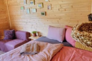 a room with purple and pink pillows and a couch at Nature retreat in a beautiful off-grid cabin in Rouge