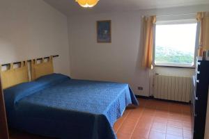 - une chambre avec un lit bleu et une fenêtre dans l'établissement LA FINESTRA SUL GOLFO - CITRA 010018-LT-0033 -, à Cogorno