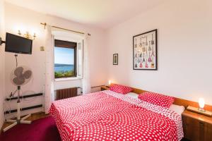 Schlafzimmer mit einem roten und weißen Bett und einem Fenster in der Unterkunft BROZINA in Crikvenica